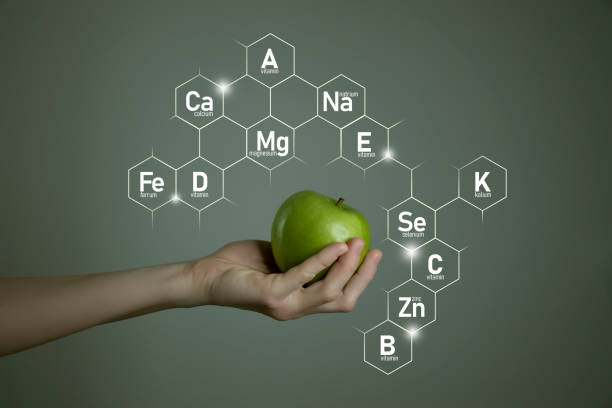 Woman`s hand holding green apple, microelement icons in molecular hexagons on grey background.
