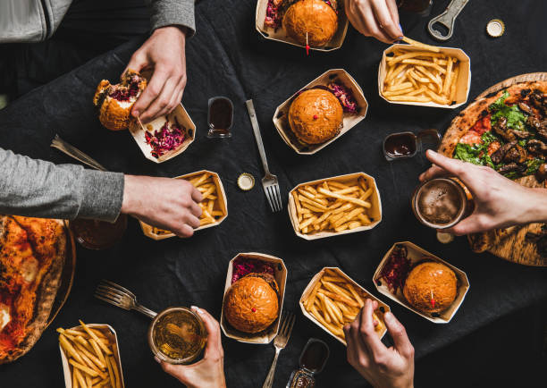 lay piatto di persone che mangiano cibo dal servizio di consegna a casa - burger french fries cheeseburger hamburger foto e immagini stock
