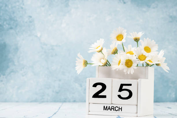 istock White cube calendar for march decorated with daisy flowers over blue with copy space 1306193701