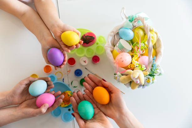 istock Hands of family members are holding many painted Easter eggs. Easter decoration concept 1306193748