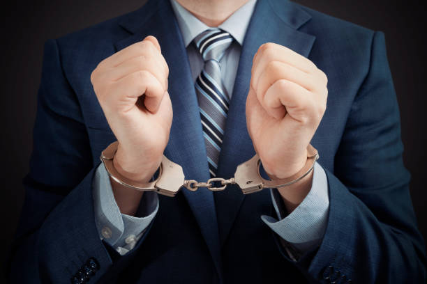 Businessman arrested, man in suit with handcuffs Businessman arrested for corruption. Man in a suit with handcuffs on his hands white collar crime handcuffs stock pictures, royalty-free photos & images