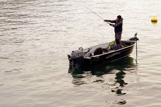 хобби рыбак литья удочку на озере цюрих в зимний период. - recreational boat nautical vessel fishing rod motorboat стоковые фото и изображения