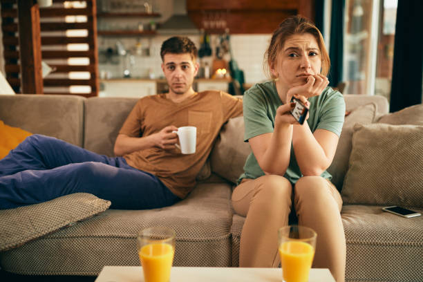 istock Young woman feeling bored while changing channels on TV at home. 1306198131