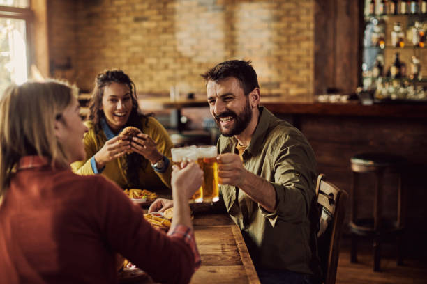 istock Cheerful man toasting with friends while having lunch in a pub. 1306198586
