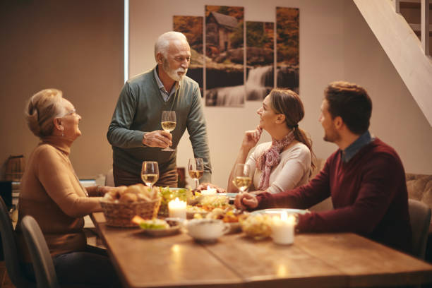 istock Happy senior man proposing a toast during family dinner at dining table. 1306199611