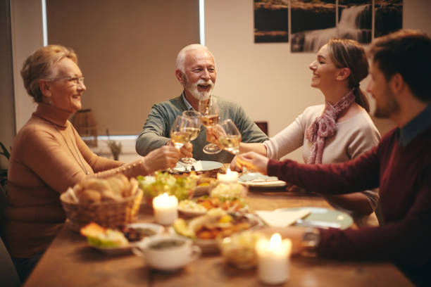 istock Cheerful family toasting with wine during lunch at dining table. 1306199795