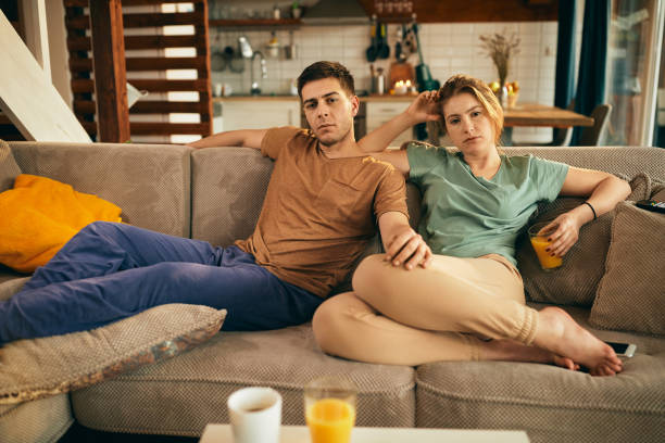 istock Young couple watching TV while relaxing on the sofa at home. 1306201076
