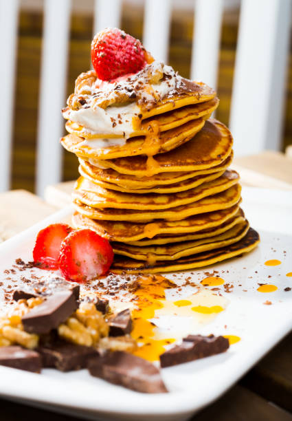 istock Stack of sweet pancakes with  fruit, honey, chocolate and whipped cream 1306202177