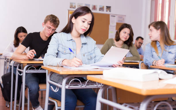 istock Smiling schoolgirl is learning and answering the question on paper 1306202251