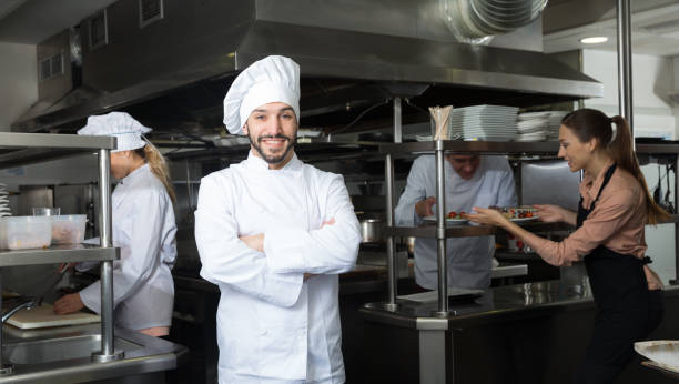 istock Chef in kitchen on background with employees 1306202391