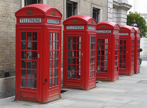 A line of classic vintage (1930's) public telephone boxes (kiosks) in central London