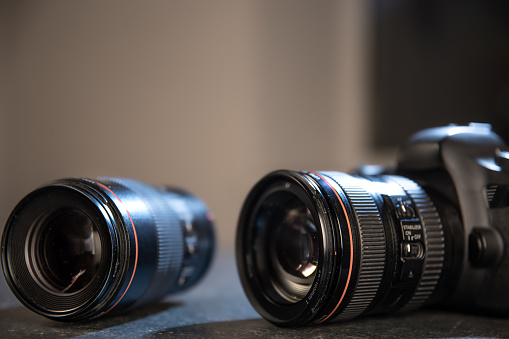 Professional camera close-up on a photographer's desktop on a blurred background. The concept of professional equipment for photo and video.