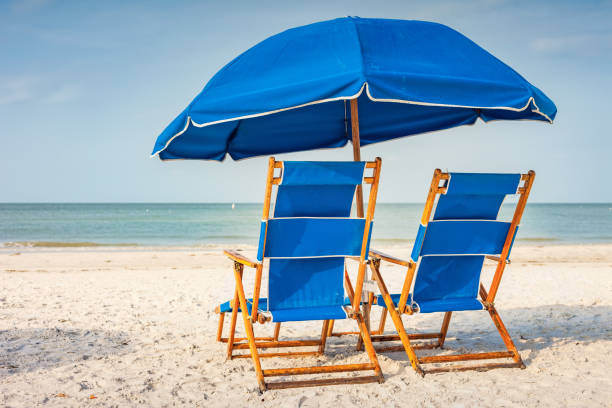 istock Beach with Lounge Chairs and Umbrella 1306208334