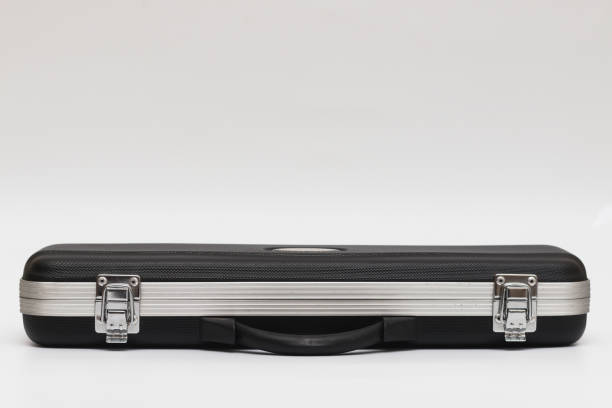 istock Small long black suitcase with locks for flute on a white background 1306208390