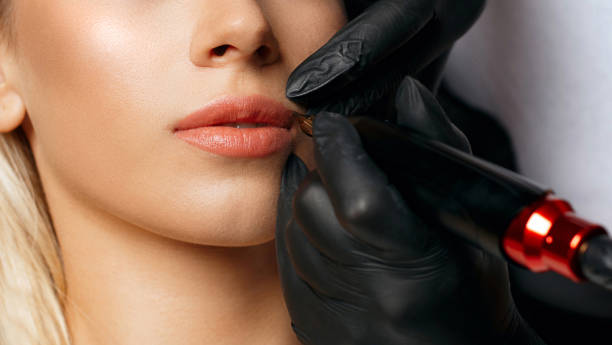 istock Beauty specialist applying lip tattoo 1306213668