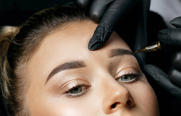istock Woman in gloves applying eyebrow permanent makeup 1306213683