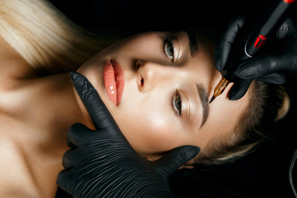 istock Woman in gloves doing permanent makeup 1306213687