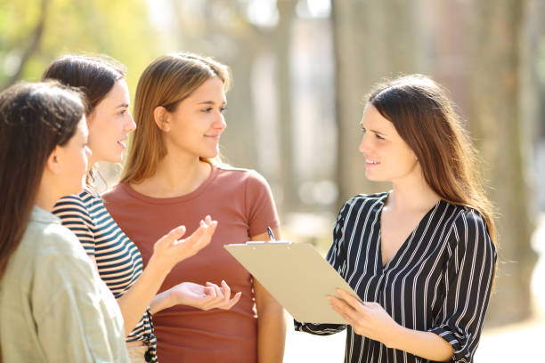 woman surveying three people in the street - nature writing women ideas imagens e fotografias de stock