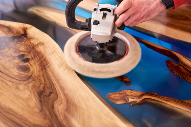 man polishing epoxy table close up stock photo