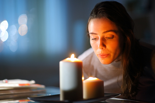 Mujer soplando velas en casa en la noche photo