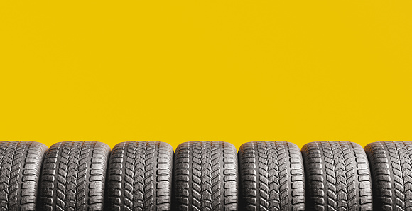 yellow background with tires peeking out from the bottom