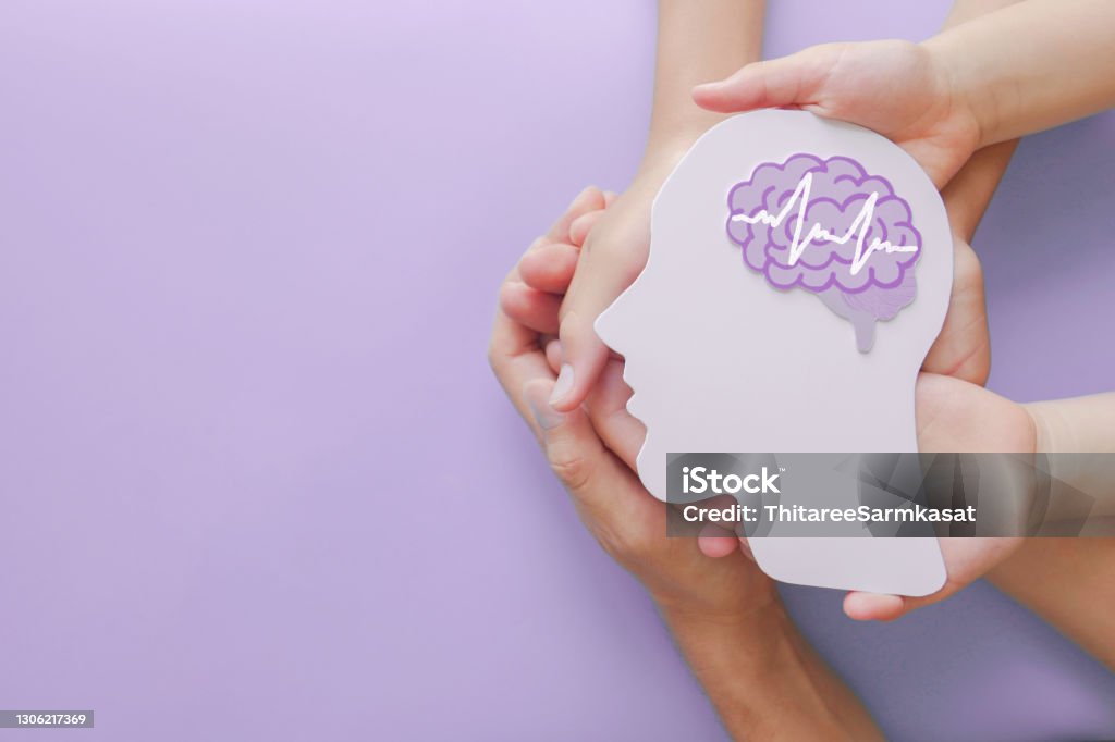 Adult and child hands holding encephalography brain paper cutout,autism, Stroke, Epilepsy and alzheimer awareness, seizure disorder, stroke, ADHD, world mental health day concept Mental Health Stock Photo
