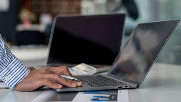 istock Young businessman working at home with laptop and documents on the graph, desk, close view 1306220830