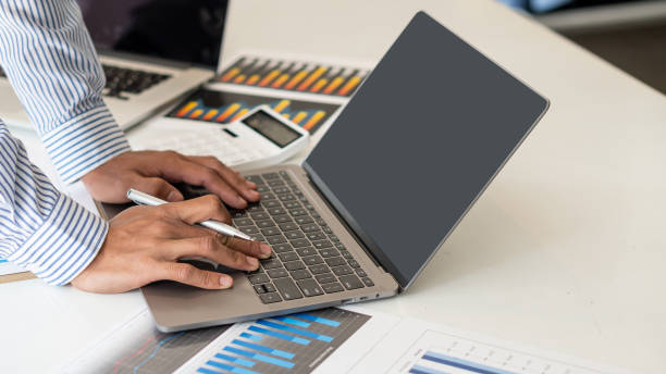 istock Young businessman working at home with laptop and documents on the graph, desk, close view 1306220841