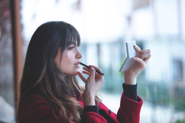 istock Attractive young woman doing make-up while looking at the mirror 1306221796