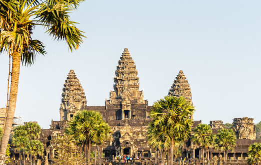 Angkor Wat, Cambodia - January 20, 2020: Lotus bud shaped towers of Angkor Wat is lit by the setting Sun. The Angkor Wat is a Hindu temple complex in Cambodia and is the largest religious monument in the world.