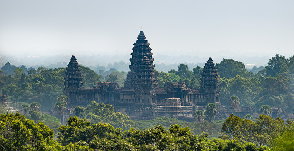 Siem Reap, Cambodia - January 24, 2020: The Angkor Wat is a Hindu temple complex in Cambodia and is the largest religious monument in the world. This photograph was taken from the hill that houses the Phnom Bakheng temple.