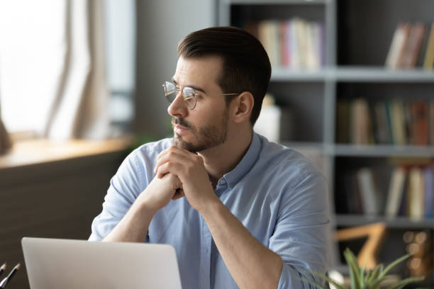 istock Pensive businessman distracted from computer work looking in distance thinking 1306230731