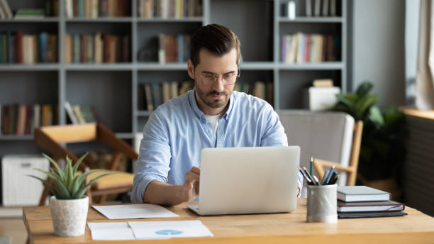 istock Focused businessman sit at workplace desk working on laptop 1306230736