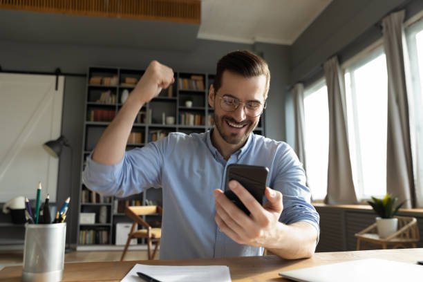 istock Man looking at smartphone screen reading message feels happy 1306230754