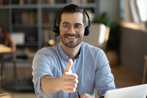 istock Man wear headset show thumbs up recommend distant training online 1306230773