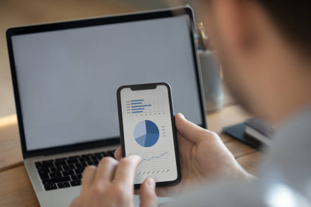 Businessman synchronize information using laptop and smartphone with financial data