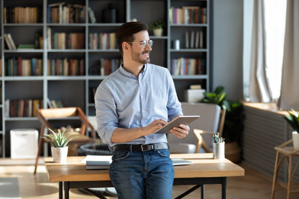 istock Entrepreneur holding tablet device looks out the window feels happy 1306230805