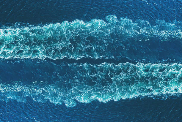 Ship's Wake Drone view of a ship's wake in open ocean. Symmetrical composite. sea wake stock pictures, royalty-free photos & images
