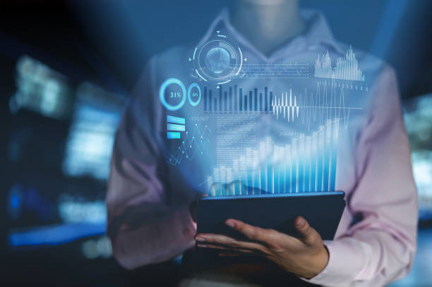 Woman analyzing the development of her business with hologram graphs on a tablet computer