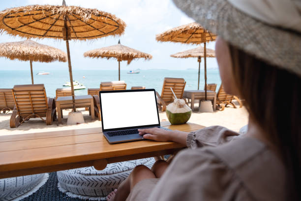 istock a woman using and touching on laptop touchpad with blank desktop screen while sitting on the beach 1306235603