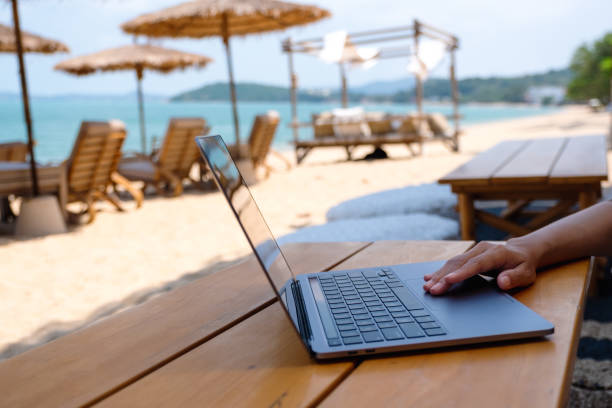 istock a woman working and touching on laptop touchpad on the beach 1306235614