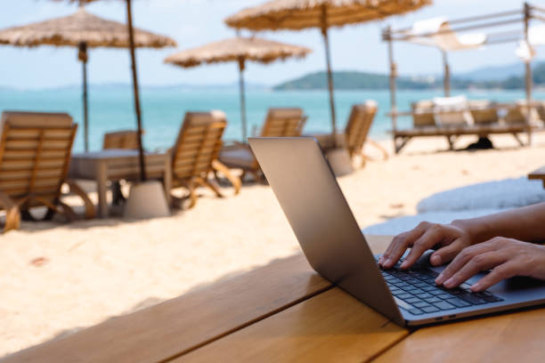 istock a woman working and typing on laptop computer on the beach 1306235631