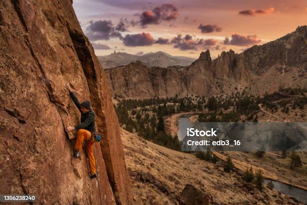 El Hombre Aventurero Está Escalando En Roca En El Lado De Un Acantilado Empinado Foto de stock y más banco de imágenes de Escalada