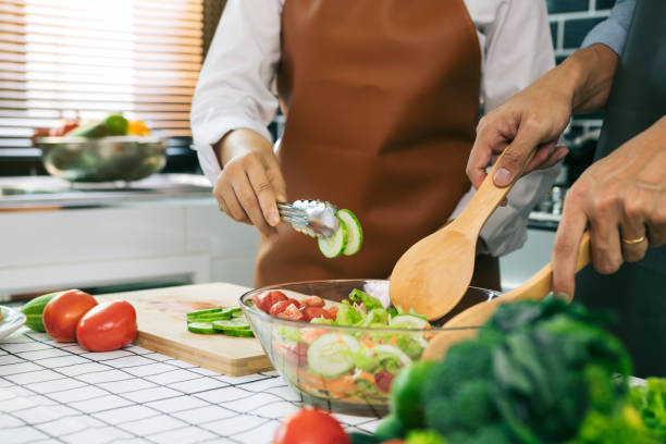 istock Asian couple preparing healthy salad in the kitchen. 1306238876