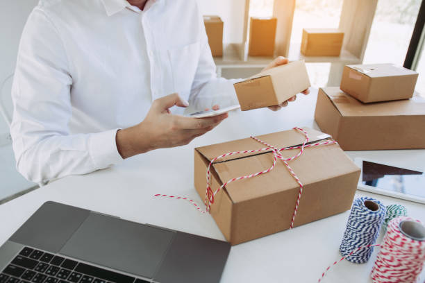 istock Asian young man using smart phone for checking shipment order at home. 1306238902