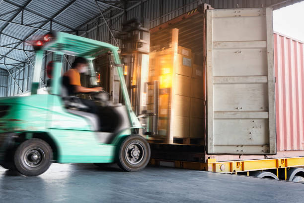istock Fast Motion Blur of Forklift Driver Loading Shipment Boxes into Cargo Container Truck. Shipping Warehouse. Industry Freight Truck Transportation. 1306241168