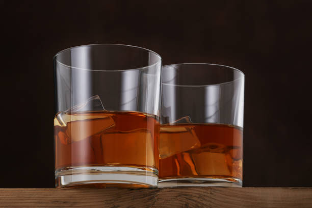 istock Glasses of whiskey on brown background. Closeup 1306247403