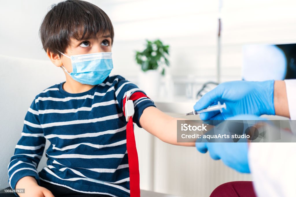 Male nurse taking blood sample of child patient ın clinic Child Stock Photo