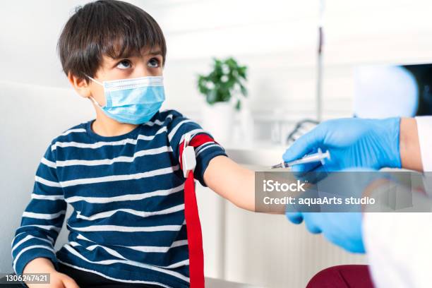 Male Nurse Taking Blood Sample Of Child Patient In Clinic Stock Photo - Download Image Now