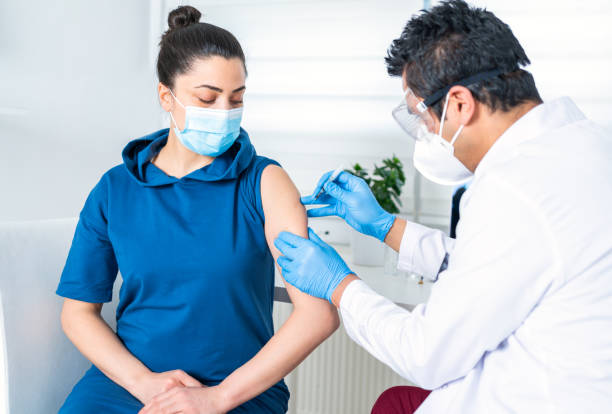 istock Young woman being vaccinate at doctor's office. Vaccination while a global pandemic 1306247447